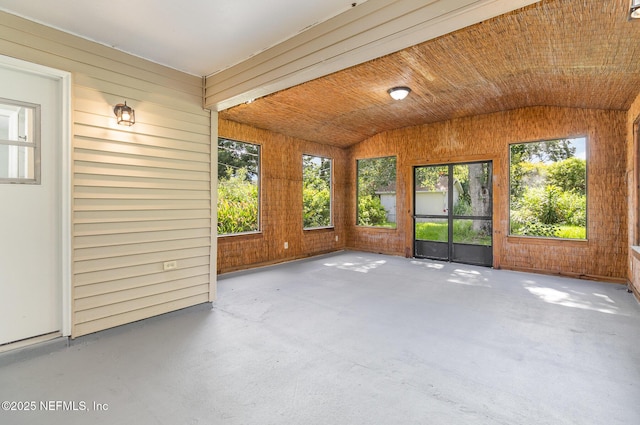 unfurnished sunroom with vaulted ceiling, plenty of natural light, and wood ceiling