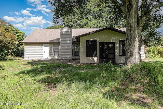 back of property featuring a yard