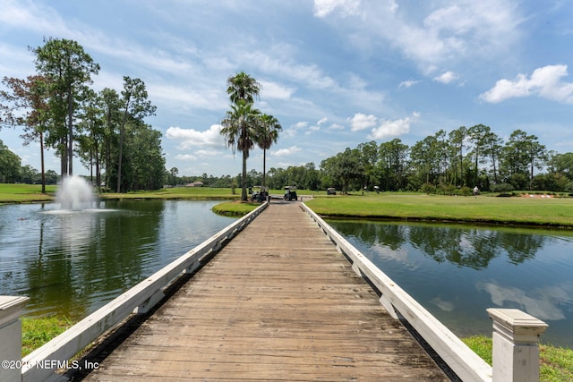 dock area with a yard and a water view