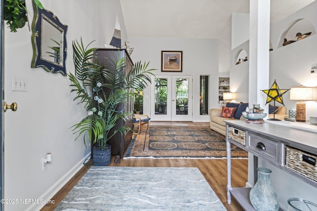 entryway with french doors, dark hardwood / wood-style floors, and lofted ceiling