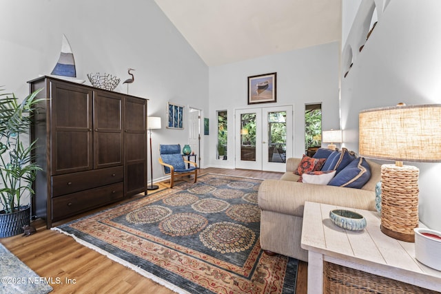 living room featuring hardwood / wood-style floors, high vaulted ceiling, and french doors