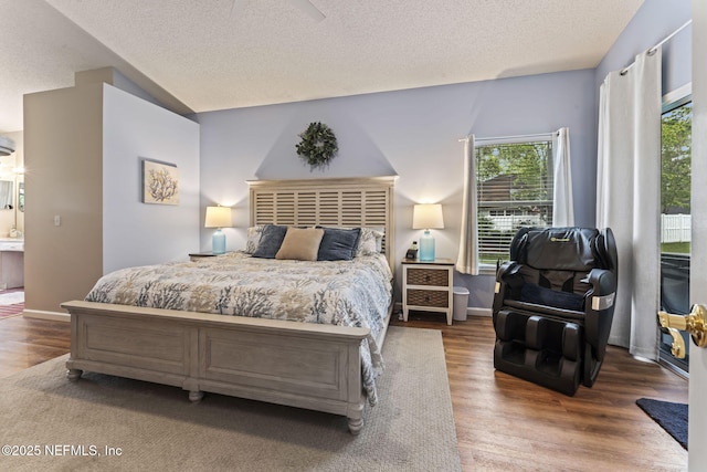 bedroom with ensuite bathroom, ceiling fan, wood-type flooring, and a textured ceiling