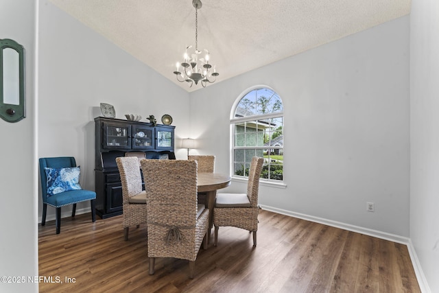 dining space featuring a notable chandelier, dark hardwood / wood-style flooring, a textured ceiling, and vaulted ceiling