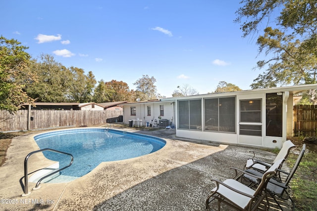 view of pool featuring a sunroom, a patio, and central AC