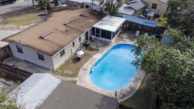 view of pool with central air condition unit and a sunroom