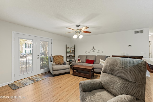 living room with ceiling fan, french doors, and light hardwood / wood-style flooring