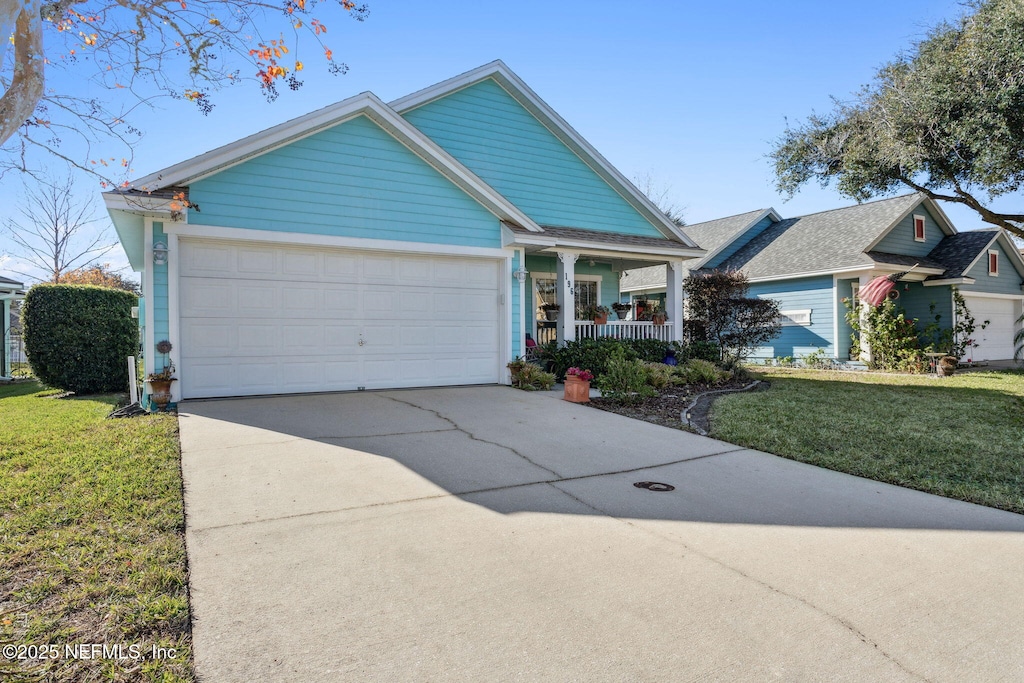 view of front of property featuring a front yard, a porch, and a garage