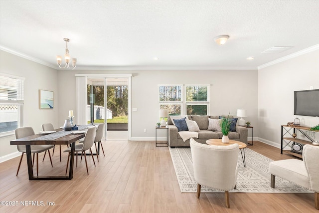 living room featuring a textured ceiling, crown molding, a notable chandelier, and light wood-type flooring