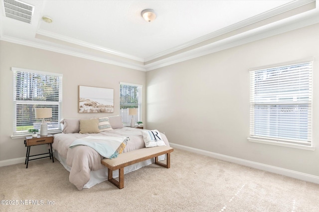 carpeted bedroom featuring ornamental molding and a tray ceiling