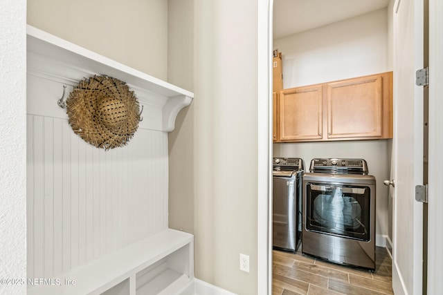 washroom with cabinets and washing machine and clothes dryer