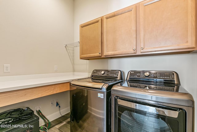 clothes washing area with washing machine and dryer and cabinets