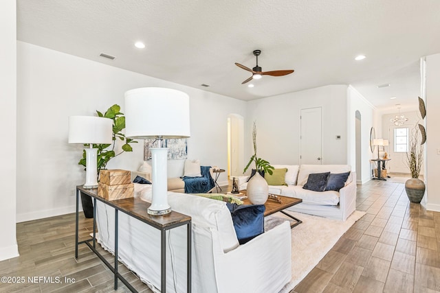 living room with ceiling fan and a textured ceiling