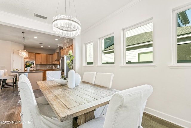 dining room featuring ornamental molding, dark hardwood / wood-style floors, and a notable chandelier