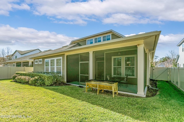 back of property with a lawn and a sunroom