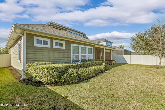 back of property with a sunroom and a yard