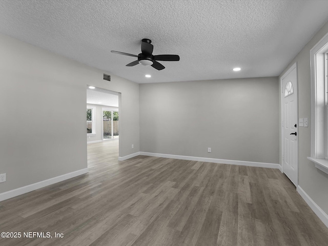 spare room featuring ceiling fan, a textured ceiling, and light wood-type flooring