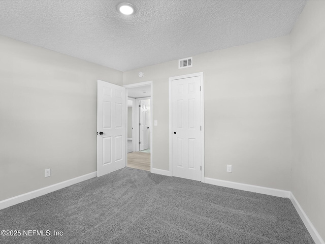 carpeted spare room with a textured ceiling