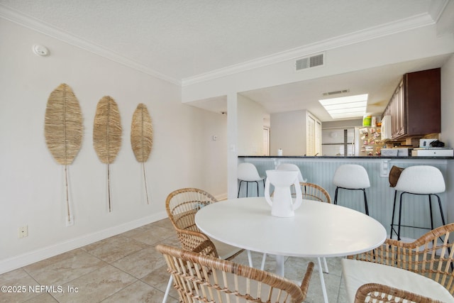 dining space featuring crown molding, light tile patterned floors, and a textured ceiling