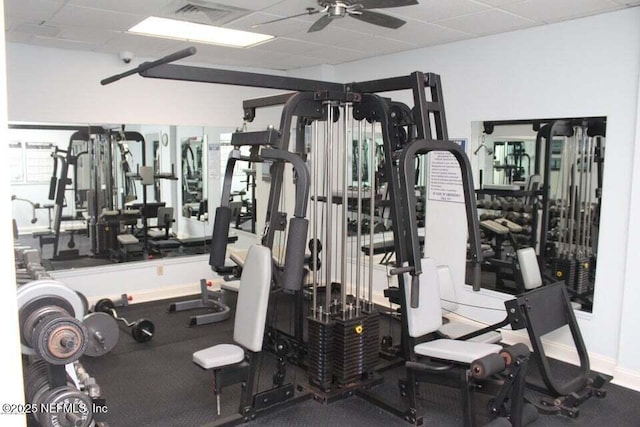 gym with a paneled ceiling and ceiling fan