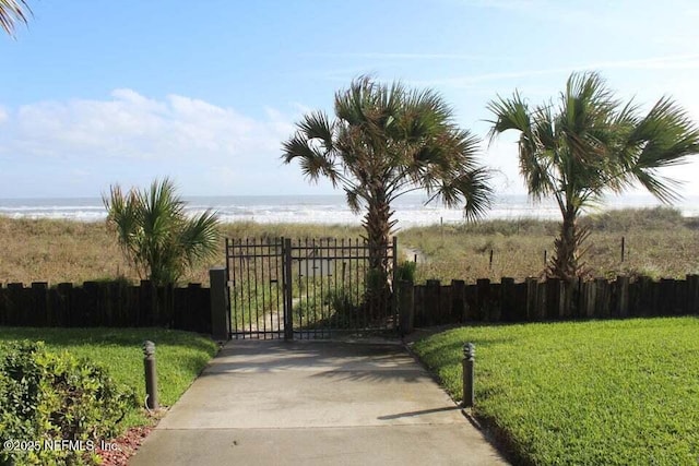 view of gate featuring a yard and a water view