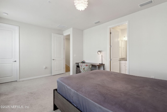 bedroom with light carpet and ensuite bathroom