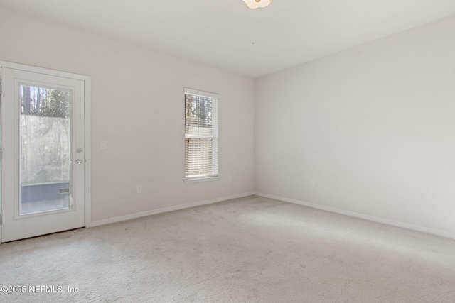 unfurnished room with light colored carpet and plenty of natural light