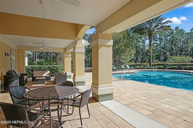 view of pool featuring ceiling fan, a patio, and an outdoor living space