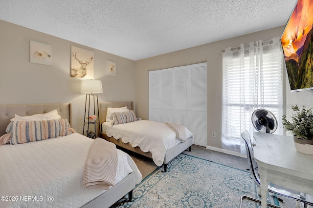 carpeted bedroom featuring a textured ceiling and a closet