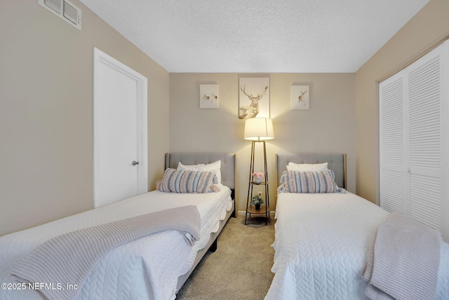 carpeted bedroom with a textured ceiling and a closet