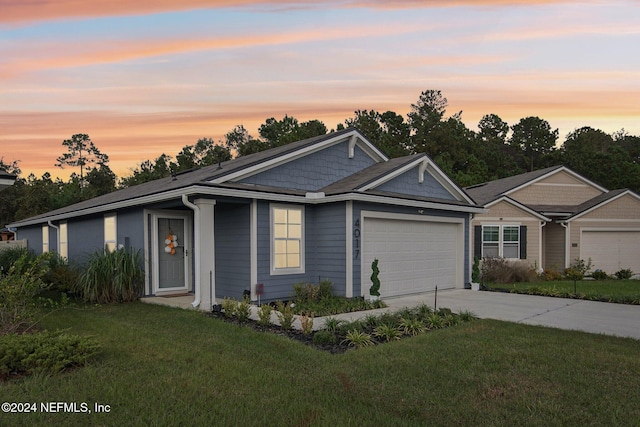 ranch-style house with a garage and a yard