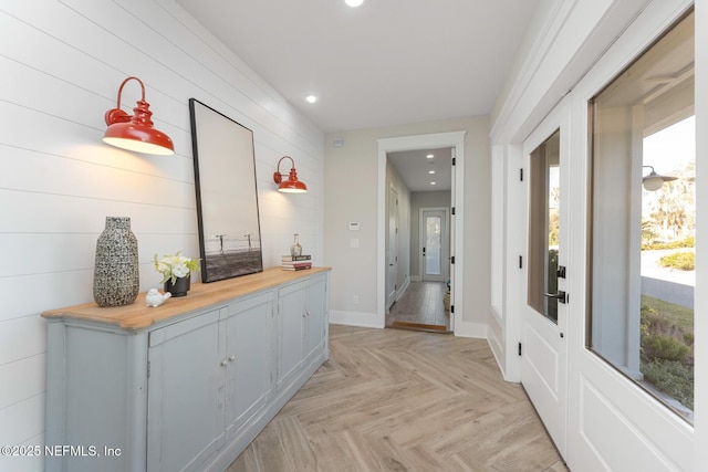 corridor with light parquet flooring and a healthy amount of sunlight