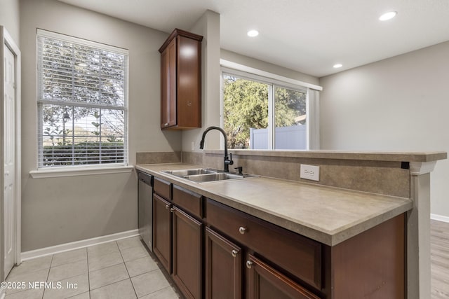 kitchen featuring light tile patterned floors, stainless steel dishwasher, a healthy amount of sunlight, and sink