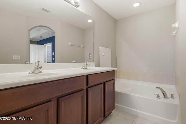 bathroom featuring tile patterned floors, vanity, and a bathing tub