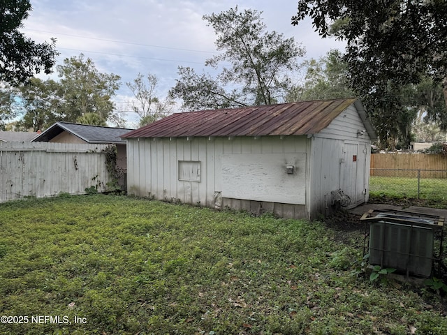 view of outbuilding with a lawn and central air condition unit