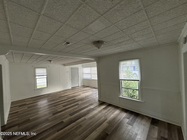 spare room featuring a paneled ceiling, hardwood / wood-style floors, and plenty of natural light