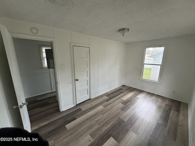 unfurnished room featuring dark hardwood / wood-style floors and a textured ceiling