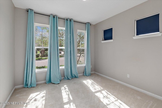 spare room with plenty of natural light and light colored carpet