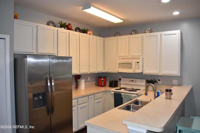 kitchen featuring white appliances, white cabinets, sink, a kitchen bar, and kitchen peninsula