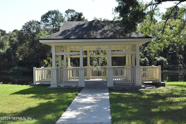 view of front of property with a gazebo, a water view, and a front lawn