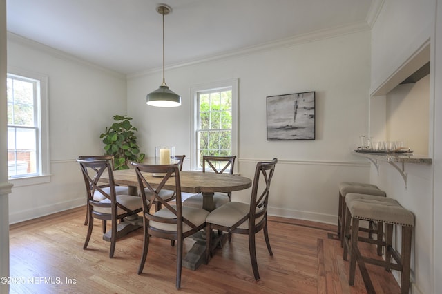 dining room with hardwood / wood-style floors and ornamental molding