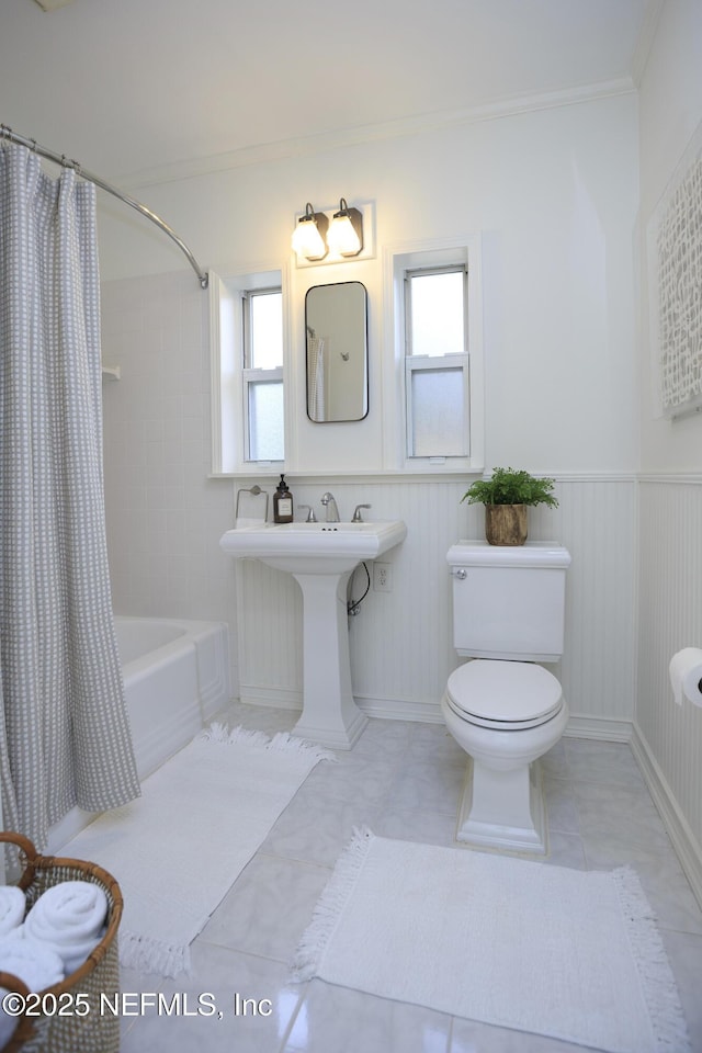 bathroom featuring ornamental molding, toilet, tile patterned flooring, and shower / bath combo with shower curtain