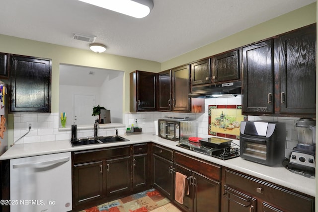 kitchen with backsplash, black appliances, sink, light tile patterned floors, and dark brown cabinets