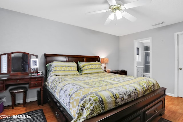 bedroom with hardwood / wood-style floors, connected bathroom, and ceiling fan