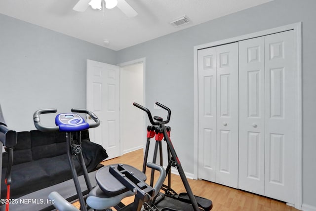 workout area featuring light wood-type flooring and ceiling fan