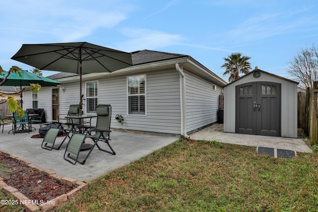 rear view of house with a storage unit, a patio area, and a yard