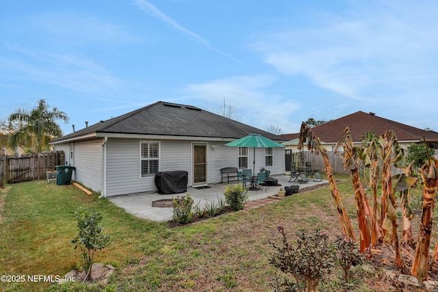 rear view of house with a patio area and a lawn