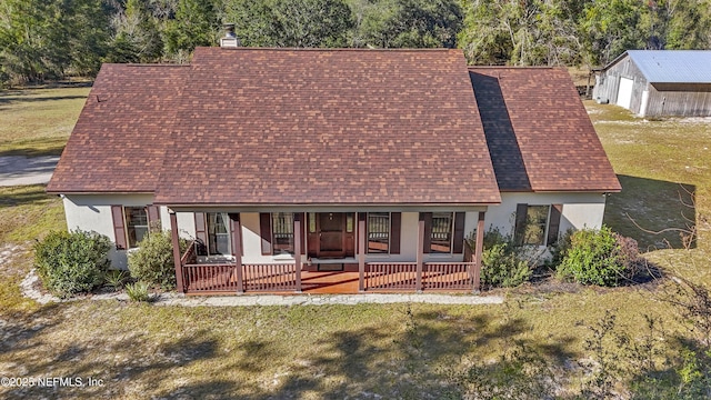 back of property featuring a yard and covered porch