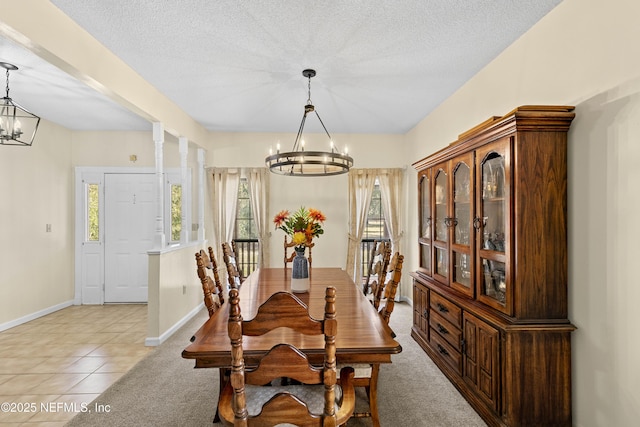 dining area with light tile patterned flooring, a textured ceiling, and a chandelier