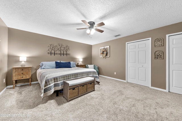 bedroom with ceiling fan, a textured ceiling, and light carpet