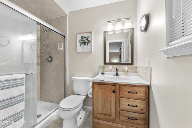 bathroom featuring tile patterned flooring, toilet, a shower with door, and vanity